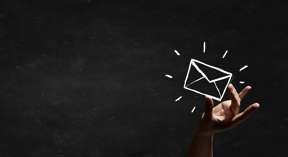 Person hand taking chalk drawn email sign